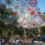 Una veintena de mujeres tejen 'Sueños de colores' para dar sombra a la plaza principal de Azucaica